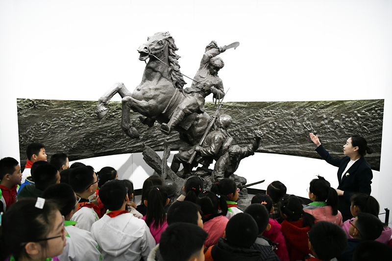 2019年4月4日，在東北烈士紀(jì)念館，學(xué)生們?cè)诼?tīng)講解員講解。